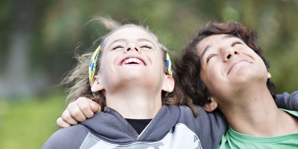 Två barn tittar upp i luften.