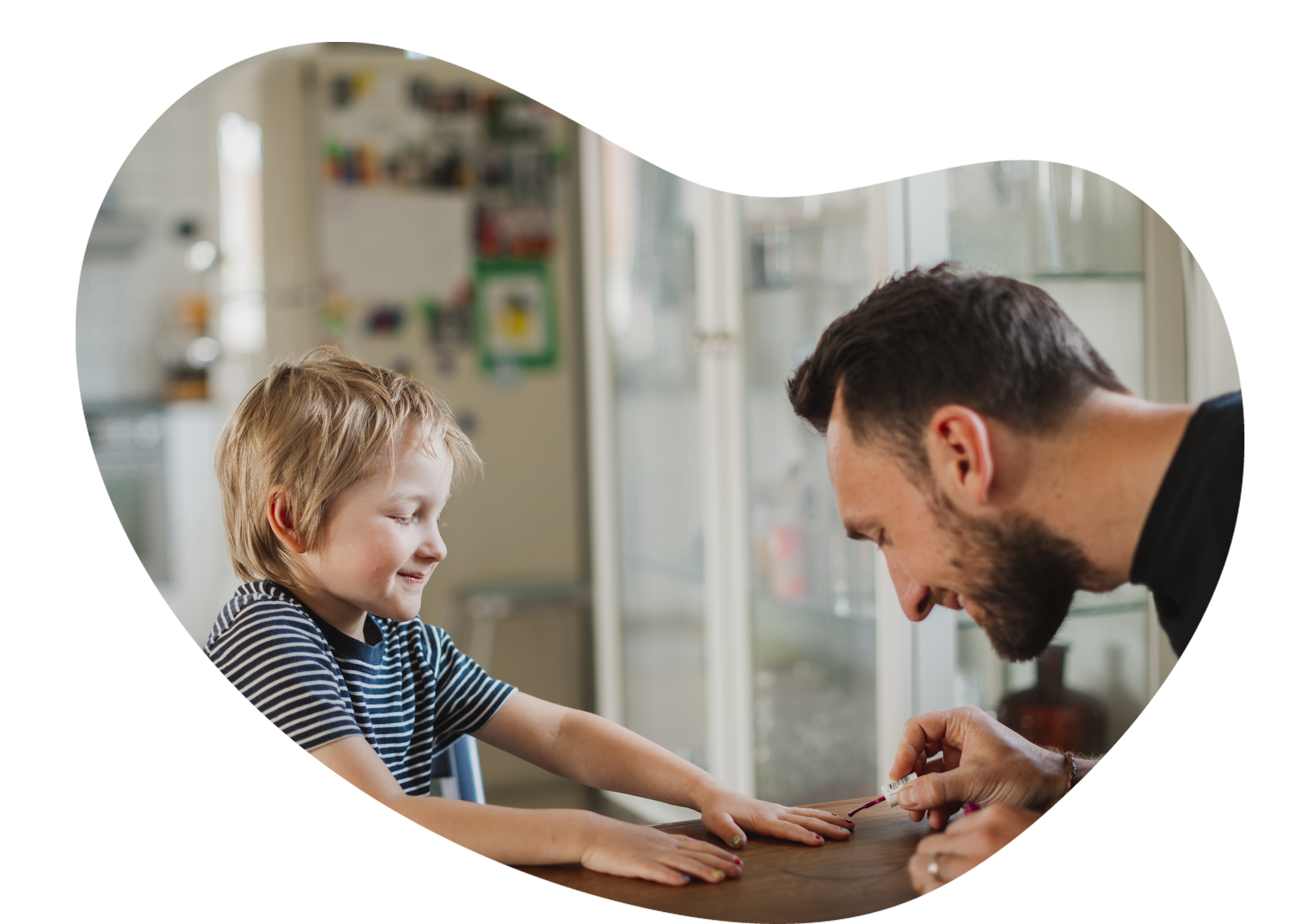 En man målar naglarna på en pojke